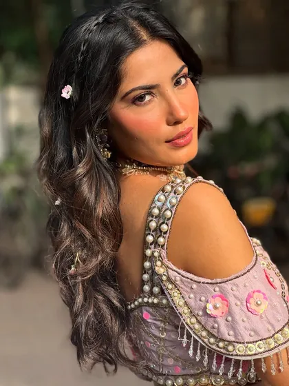 A back view of this romantic Mehendi hairstyle. I created soft waves and added delicate braids and tiny pink flowers for a whimsical, fairytale touch.