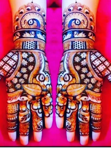 This striking design uses bold lines and dark shading to create high contrast. It features peacock feather motifs on the wrist and auspicious swastika symbols on the palms.