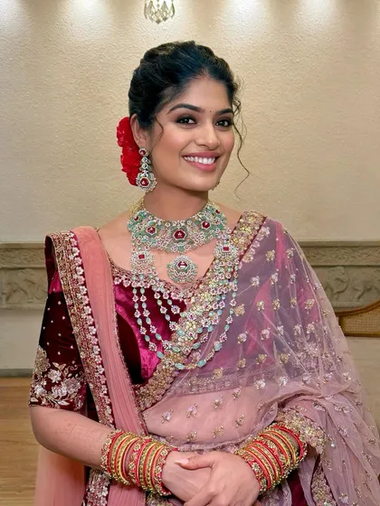 A close-up shot highlighting the beautiful smile and the stunning layered diamond and ruby necklace.