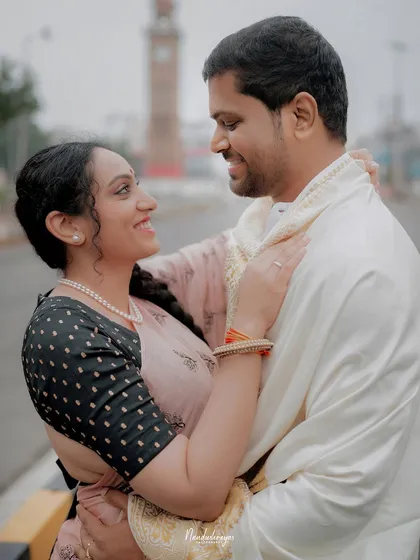 A joyful, candid embrace on a city street, with the clock tower visible in the background.
