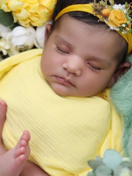 A close-up shot focusing on the newborn's tiny feet peeking out from the yellow swaddle, a detail that parents always cherish.