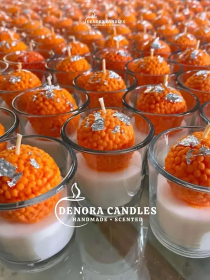 My signature laddoo candles, seen here in production, are a festive favorite. Each one is handcrafted to resemble a real motichoor laddoo, complete with silver leaf detailing, and placed in a shot glass for a modern presentation.