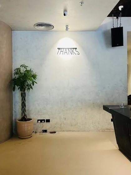 Even a single, well-placed plant can transform a room. Here, a braided Pachira tree adds life and a touch of green to a minimalist corner, softening the industrial aesthetic.