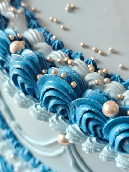 A close-up of the intricate piping work on the vintage blue heart cake, showing the layers of detail that create its classic, elegant look.