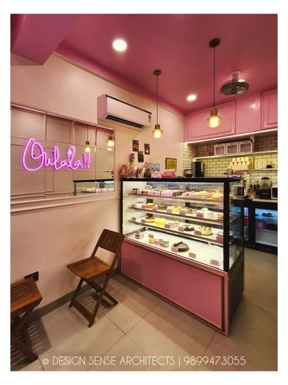 A close-up of the interior, where the "Oohlala!!" neon sign adds a playful touch. We paired simple wooden chairs with the all-pink theme to add a bit of warmth and natural texture.