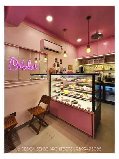 A close-up of the interior, where the "Oohlala!!" neon sign adds a playful touch. We paired simple wooden chairs with the all-pink theme to add a bit of warmth and natural texture.