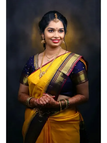 For this client's Varpooja ceremony, we chose a classic South Indian look. The makeup features defined eyes and a bright lip, complementing her beautiful yellow silk saree and traditional gold jewelry.