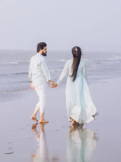 The couple walking away hand-in-hand, their reflection captured in the wet sand. This is a classic, cinematic shot that I love to create.