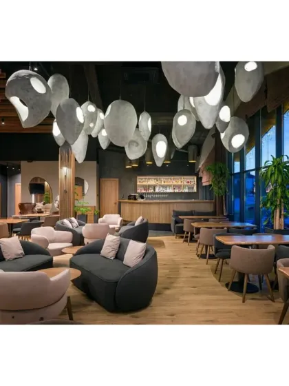 A view towards the bar, showing how the sculptural lights create a dramatic canopy over the main seating area.