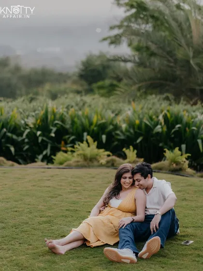 A relaxed and comfortable portrait of the couple sitting together on the grass. This shows a quiet, contented moment during their pre-wedding shoot.