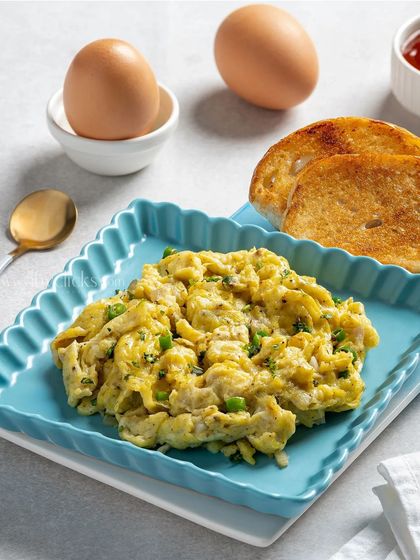 A plate of creamy scrambled eggs served with toasted bread.