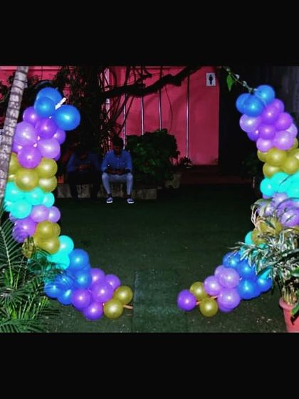 We make sure every part of your event is special, including the entrance. This heart-shaped balloon arch in peacock-inspired colors of purple, blue, and gold creates a grand welcome for guests.