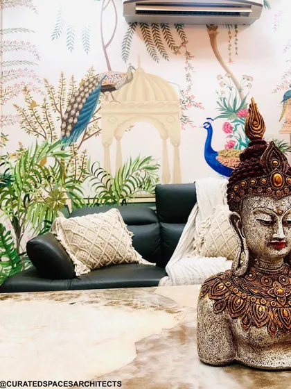 A Buddha statue brings a sense of peace and tranquility to this living space, perfectly complementing the serene, nature-themed wallpaper in the background.