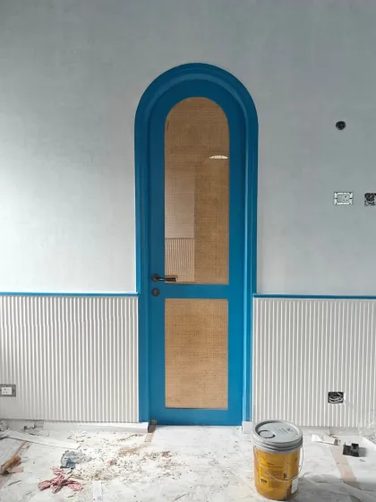 A glimpse into our process for the Greek-inspired 'AGA' project. This arched door, featuring Indonesian rattan, is set against lime-plastered walls, showcasing how we bring together materials and craftspeople from across the country to create a cohesive story.