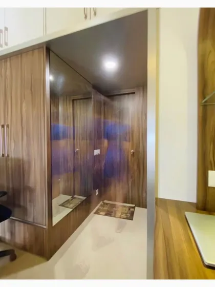 This view shows the seamless integration of the wooden wardrobe and mirror, reflecting our commitment to creating functional and aesthetically pleasing storage solutions.