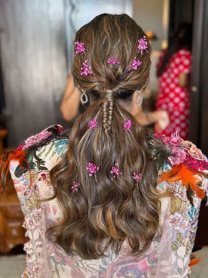 The detail of the small braid woven into the ponytail adds another layer of texture and interest to this beautiful floral hairstyle.