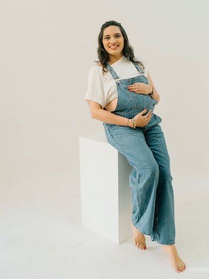 A sweet and happy portrait. The denim overalls and white tee create a classic, comfortable look that lets her personality shine through.