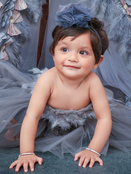 A unique and whimsical portrait with a feather-adorned teepee and a beautiful grey tulle outfit. I love creating one-of-a-kind artistic setups.