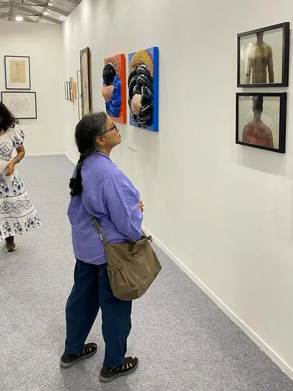A visitor contemplating the works of G. Ravinder Reddy and Sandeep T K.
