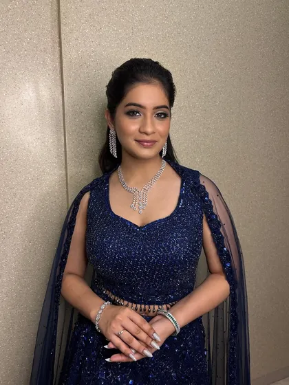 Ready for the Sangeet night. This look is all about glamour with shimmering silver eyeshadow, sharp winged liner, and a radiant complexion, paired with a stunning diamond necklace.