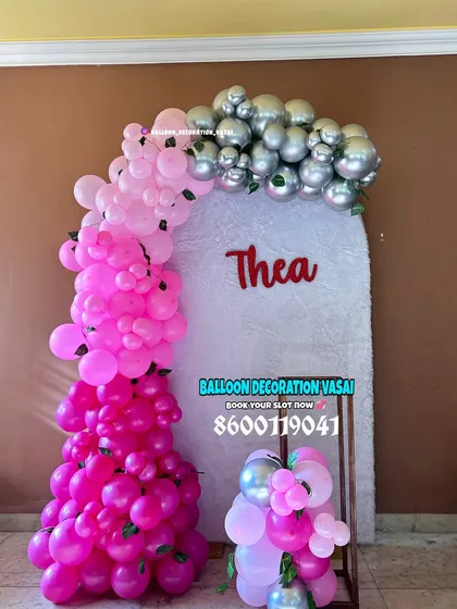 A vibrant and modern naming ceremony backdrop for a baby girl named Thea. The ombre effect of the pink balloon arch, transitioning to silver, creates a bold and stylish statement.