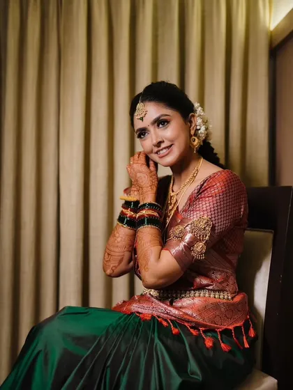 A smiling portrait of Shikha, capturing the joy and elegance of her traditional South Indian bridal attire.