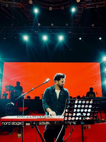 Composer Mithoon at his keyboard on a grand stage, the creative force behind our exclusive multi-artist shows.