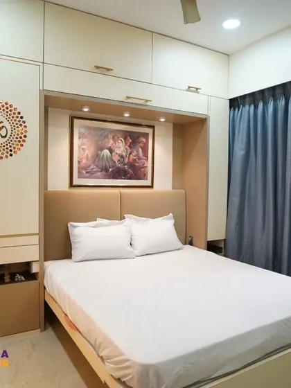 This wider view shows how the integrated wardrobe mandir fits into the overall bedroom design. It maintains the room's clean lines and modern aesthetic while providing a dedicated and personal spiritual corner, complete with storage for essentials.