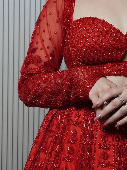 It's all in the details. A close-up of the hand-embroidered sleeve, showcasing the delicate beadwork and craftsmanship that goes into every one of our outfits.