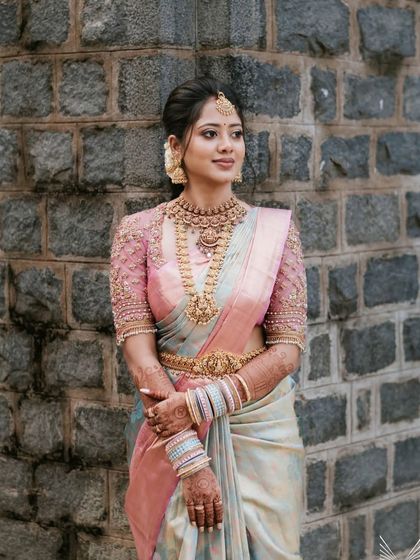 A full-length shot of Nivedha's engagement look. The layered necklaces and matching vaddanam create a complete and polished appearance.