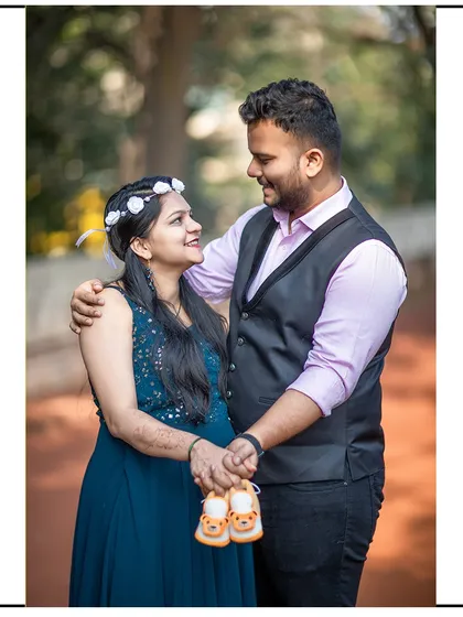A close, loving gaze between partners as they hold a pair of baby shoes.