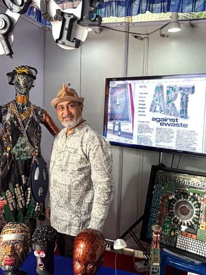 Standing with my creations at an exhibition, including a mannequin adorned with e-waste and various sculptural busts.