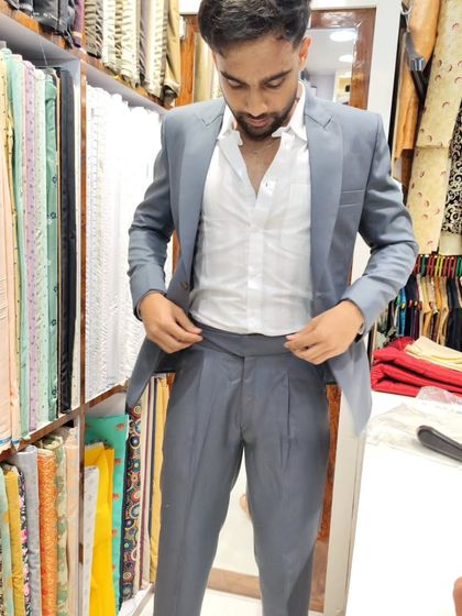 A client adjusting his custom-fit Gurkha pants. This image shows the distinctive waistband and pleated design of these highly fashionable trousers.