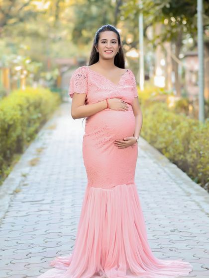 This beautiful pink lace gown with a mermaid-style train looks stunning in an outdoor setting. It combines the elegance of a studio gown with the freshness of natural light.