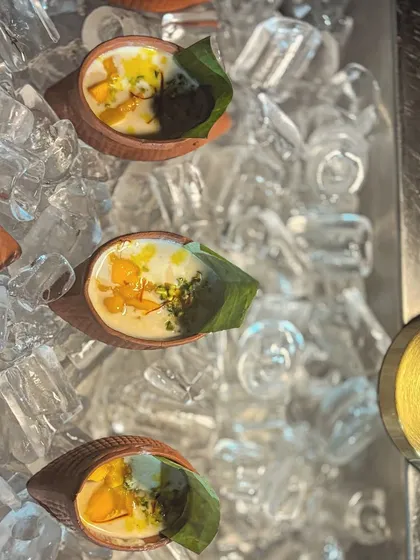 To ensure my chilled desserts are served at the perfect temperature, I present them on a bed of ice. Here, individual portions of Mango Lacha Rabdi are kept cool and refreshing for guests.