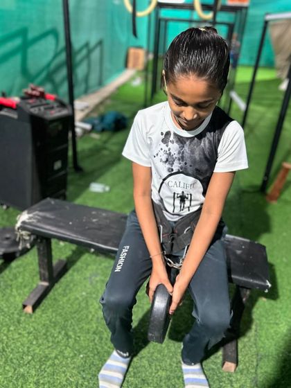 Getting ready to train. This young girl prepares for her weighted calisthenics session, showing that strength training is for everyone.