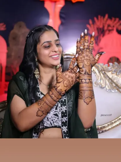 A candid shot of a happy client admiring her detailed bridal mehandi.