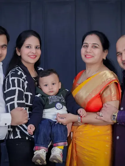 A classic portrait of three generations. The grandparents' joy is so evident as they pose with their children and grandchild. These are the photos that tell a family's story.
