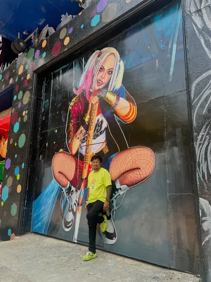 Posing in front of a large Harley Quinn mural. My brand is about being bold, edgy, and shining like the universe is yours.