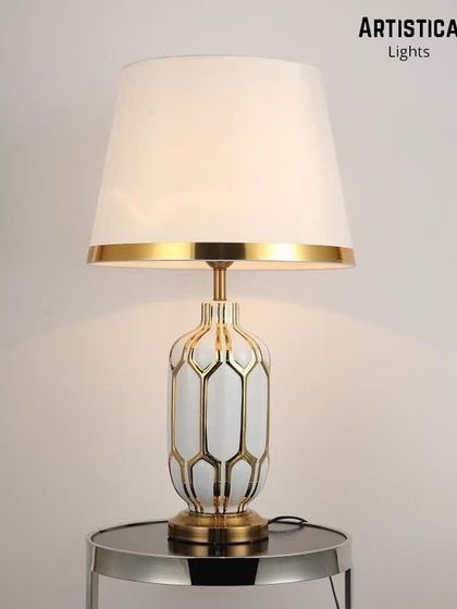 This trendy lamp brings visionary thinking to life with its cutting-edge texture and aged effect. The white and gold geometric base is designed to be a striking statement piece on any bedside table or console.
