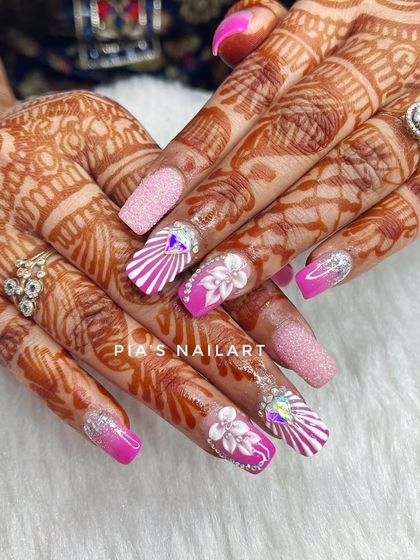 Pretty in pink for this bridal set. We combined a vibrant pink ombre, sugar glitter, and detailed white line work with 3D flowers and large crystal accents for a truly show-stopping look.