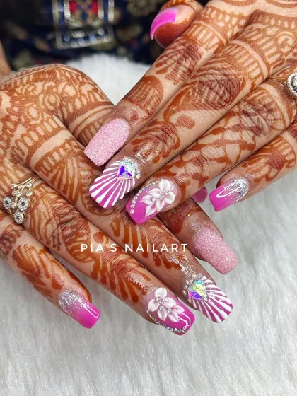 Pretty in pink for this bridal set. We combined a vibrant pink ombre, sugar glitter, and detailed white line work with 3D flowers and large crystal accents for a truly show-stopping look.