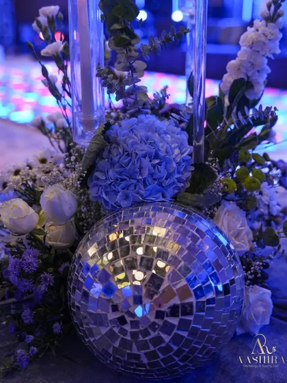 I love mixing styles. Here, a classic arrangement of hydrangeas and roses gets a funky twist with a mirrored disco ball, perfect for a glamorous cocktail party.