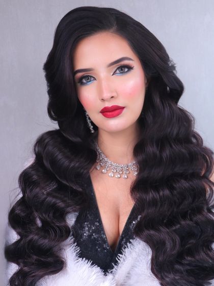 A super glam red carpet look. This features classic Hollywood waves, a bold red lip, and a flawless base, perfect for making a statement.