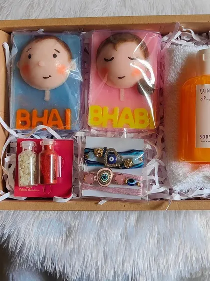 A complete "Bhai Bhabhi" Rakshabandhan hamper, featuring caricature soaps, evil eye rakhis, body wash, and a face towel.
