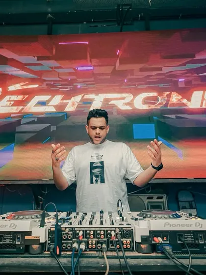 In my element, commanding the stage. This shot captures the focus and energy I put into every performance, with my custom visuals lighting up the background. A professional setup and stage presence are key to every event I do.