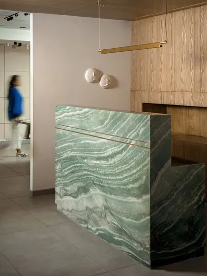 We believe in the power of a statement piece. This custom-designed reception desk, crafted from a single piece of heavily veined green marble, acts as a functional sculpture and sets a luxurious, artful tone the moment you walk in.