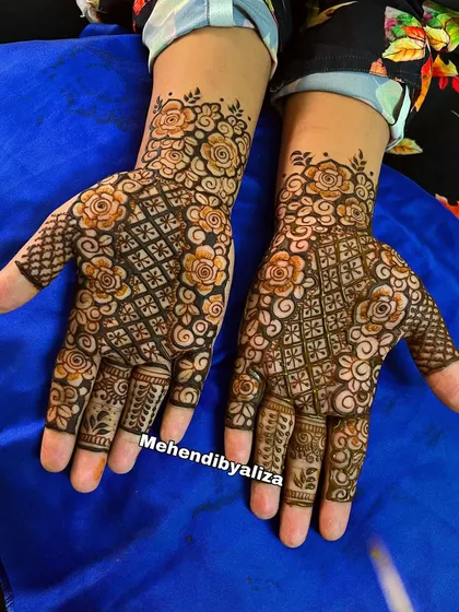 A floral henna design with a mix of roses and checkered patterns. The combination of different elements creates a unique and beautiful look.