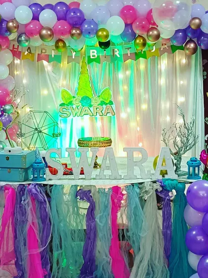 A wide view of a magical unicorn-themed birthday party, showing how we use balloons, lighting, and table decor to transform a space.