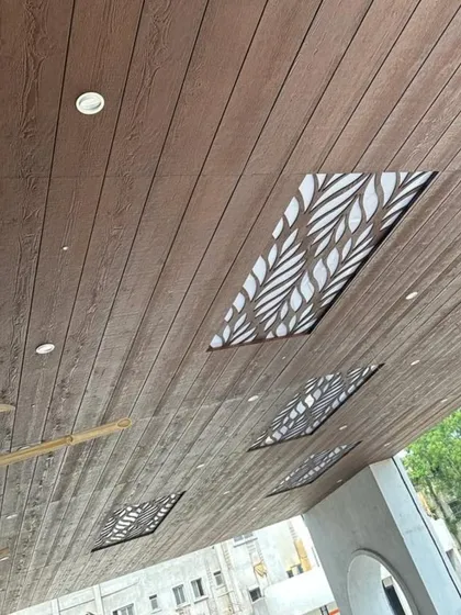 Another angle of the wooden ceiling with leaf-patterned backlit panels, showing the installation in progress with bamboo scaffolding.